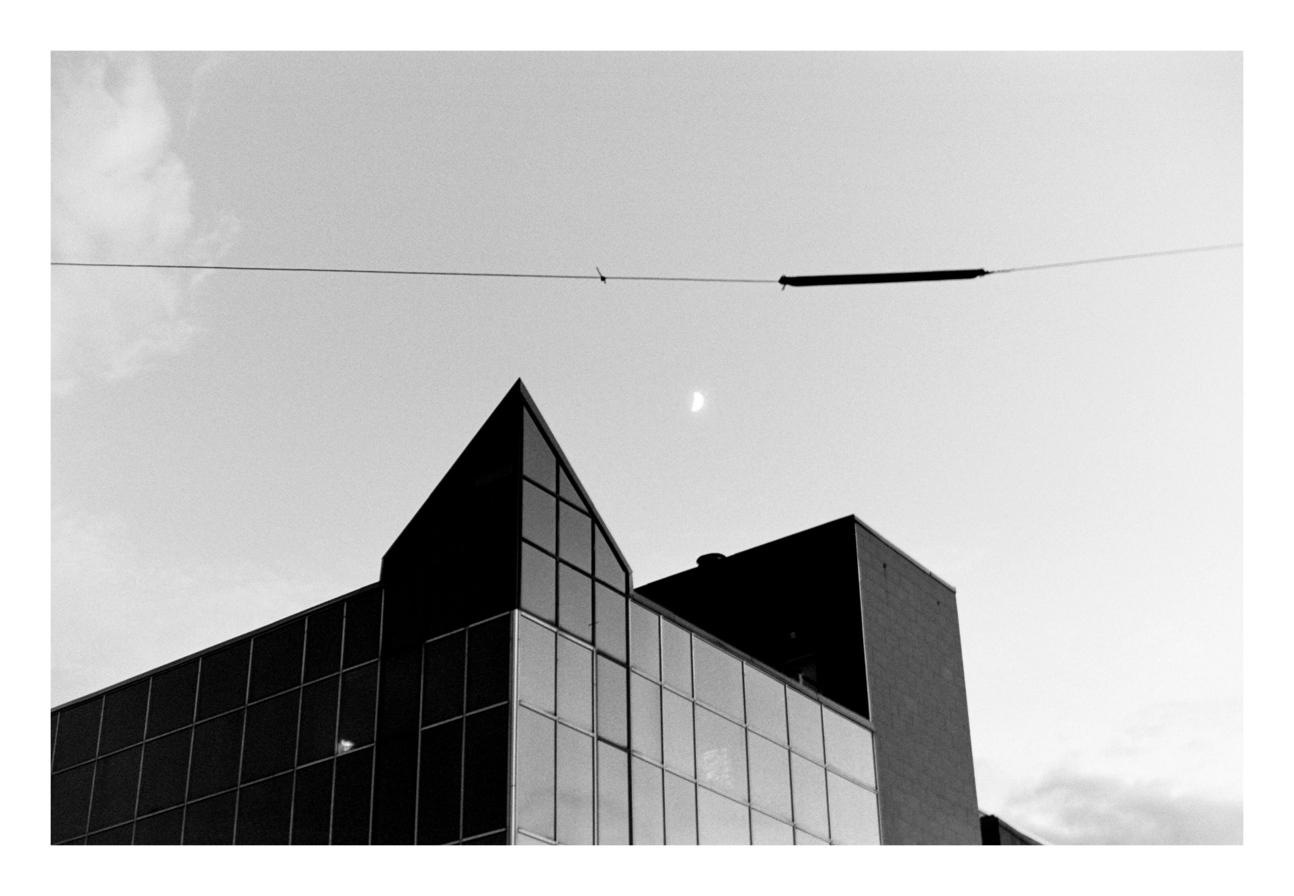 Moon over glass building black and white